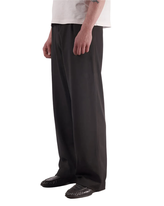 3/4 side view of Bleeding Indigo Black Lewis Trousers on a model on a white backdrop