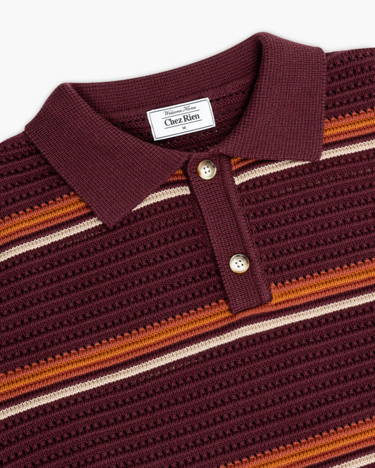 Close-up of a burgundy striped knit polo shirt with 'Chez Rien' label.