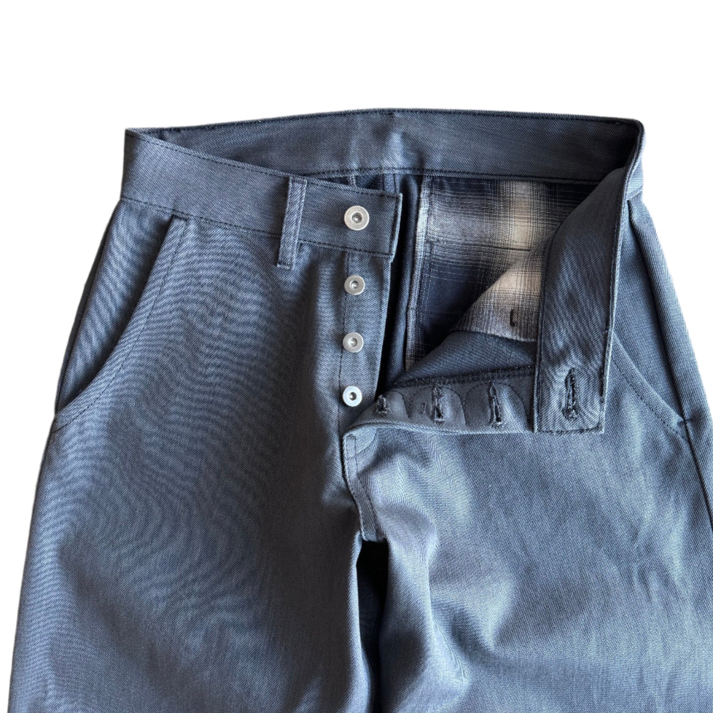The Hidden Rivet Grounded Charcoal Selvedge Denim on a pebbled brown background