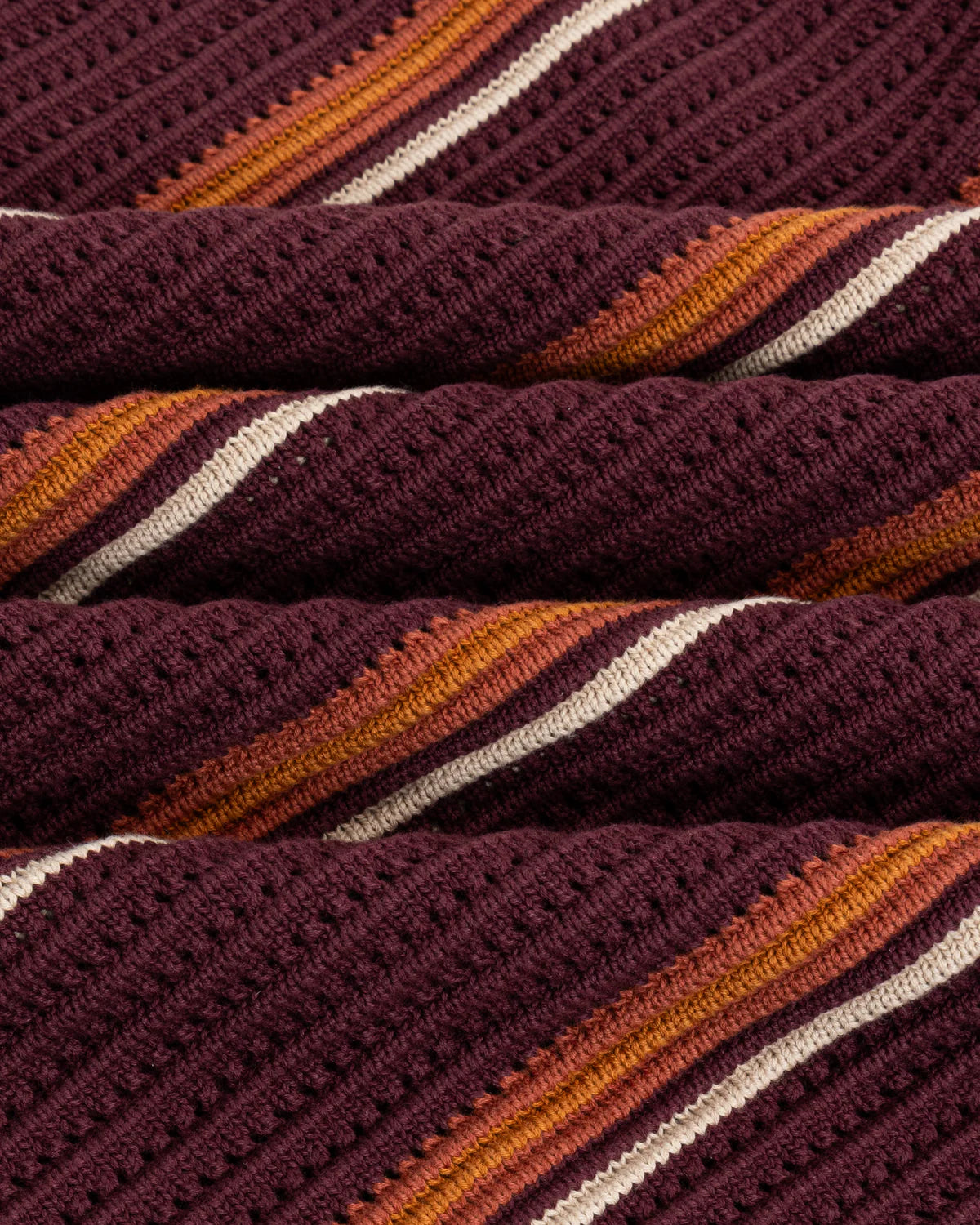 Close-up of Chez Rien’s burgundy knit fabric with purple, orange, and white stripes.