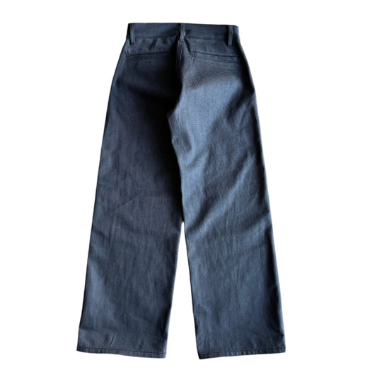 Back of The Hidden Rivet Grounded Charcoal Selvedge Denim on a pebbled brown background