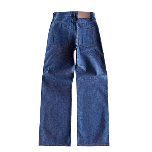 Back of The Hidden Rivet Unburden Selvedge Denim on brown pebbled background